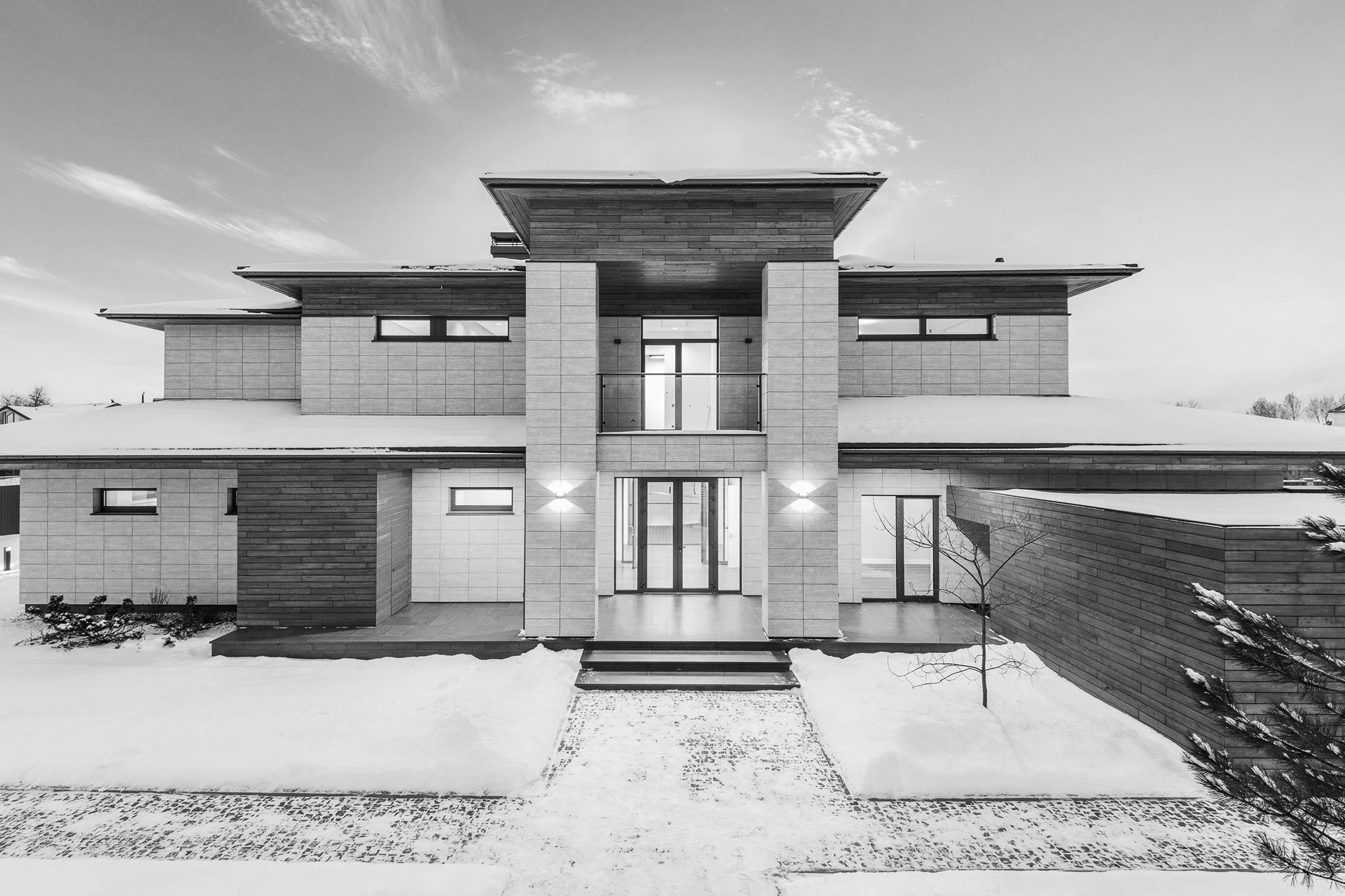 En elegant svart-hvitt fremstilling av et hus, dekket av snø, som gir en følelse av fred og stillhet.